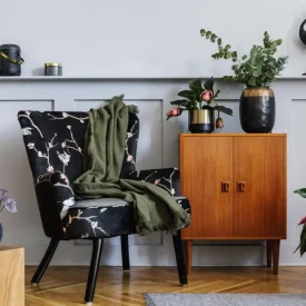 modern-interior-living-room-with-design-armchair-wooden-vintage-commode-wood-paneling-with-shelf-plants-cube-carpet-grey-wall-decoration-persnoal-accessories-home-decor-1024x683